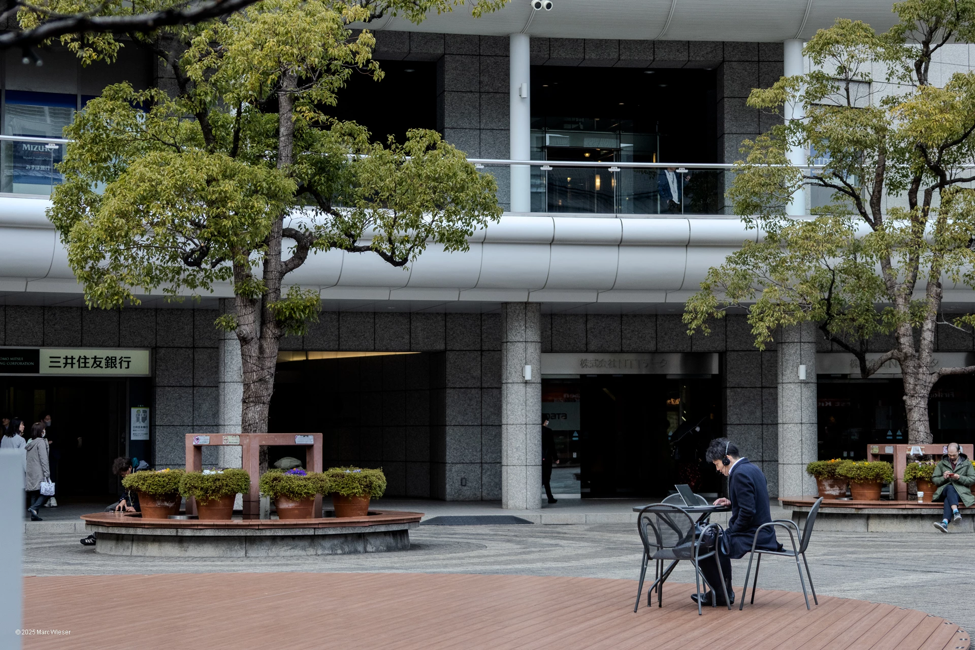 Le télétravailleur originel : Un salaryman japonais prenant un appel depuis une cours extérieure en plein Tokyo