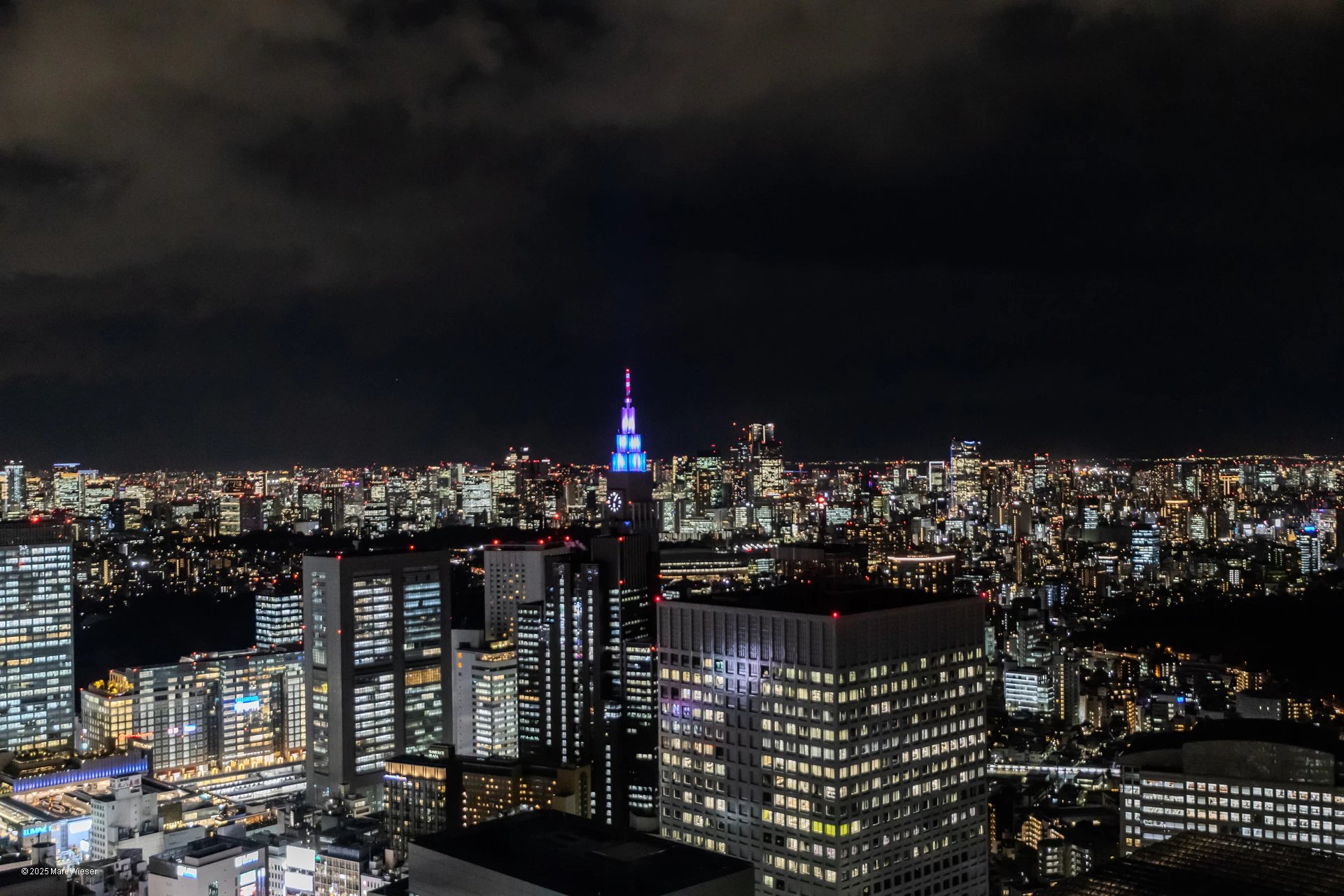 Vue sur la skyline Tokyoite de nuit du 60ème étage avec une tour au toit arc-en-ciel